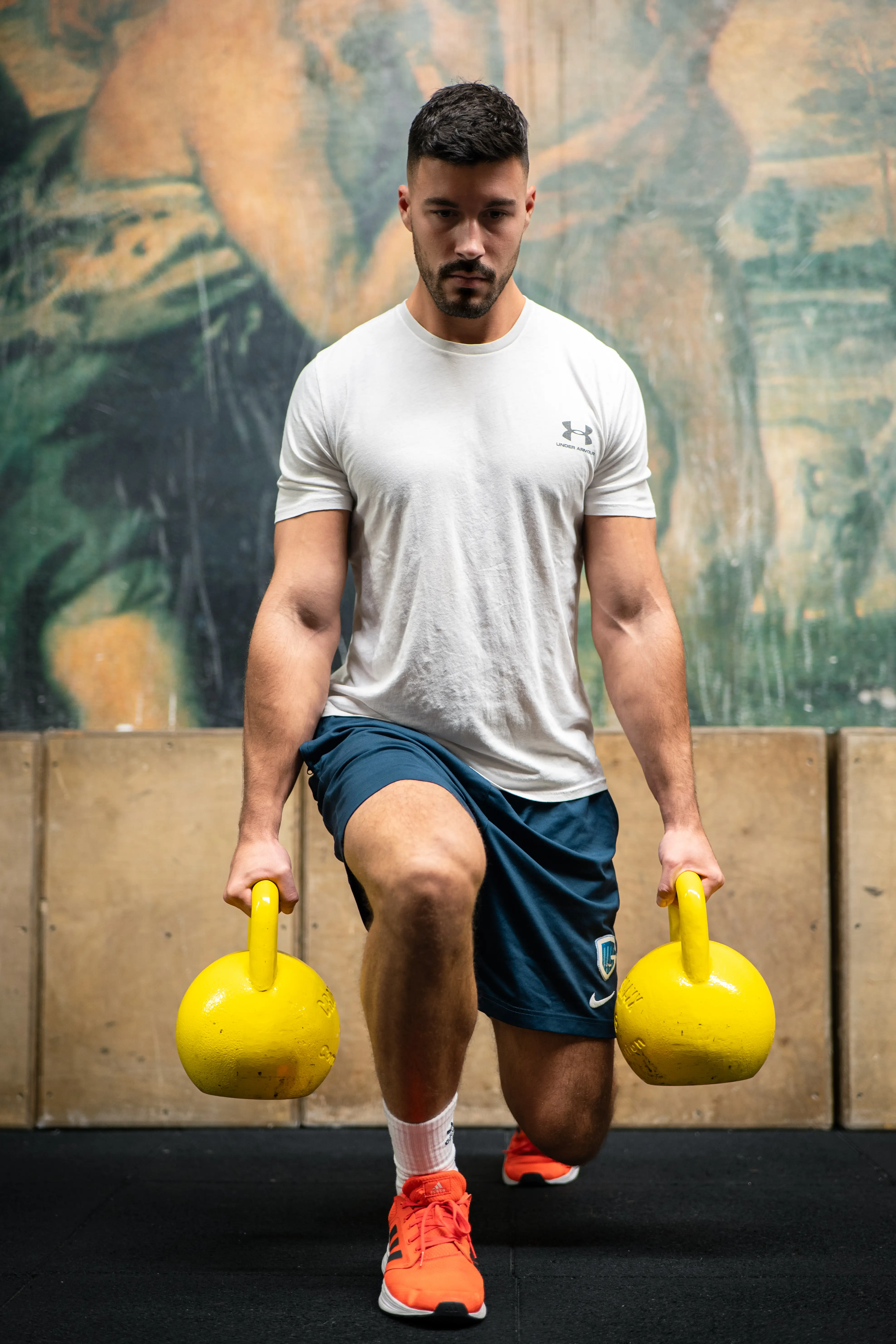 Man performing kettlebell walking lunge in a Zagreb gym — fitness photography portfolio.